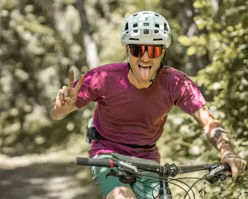 Jeune homme sur son VTT roulant avec expression très communicative